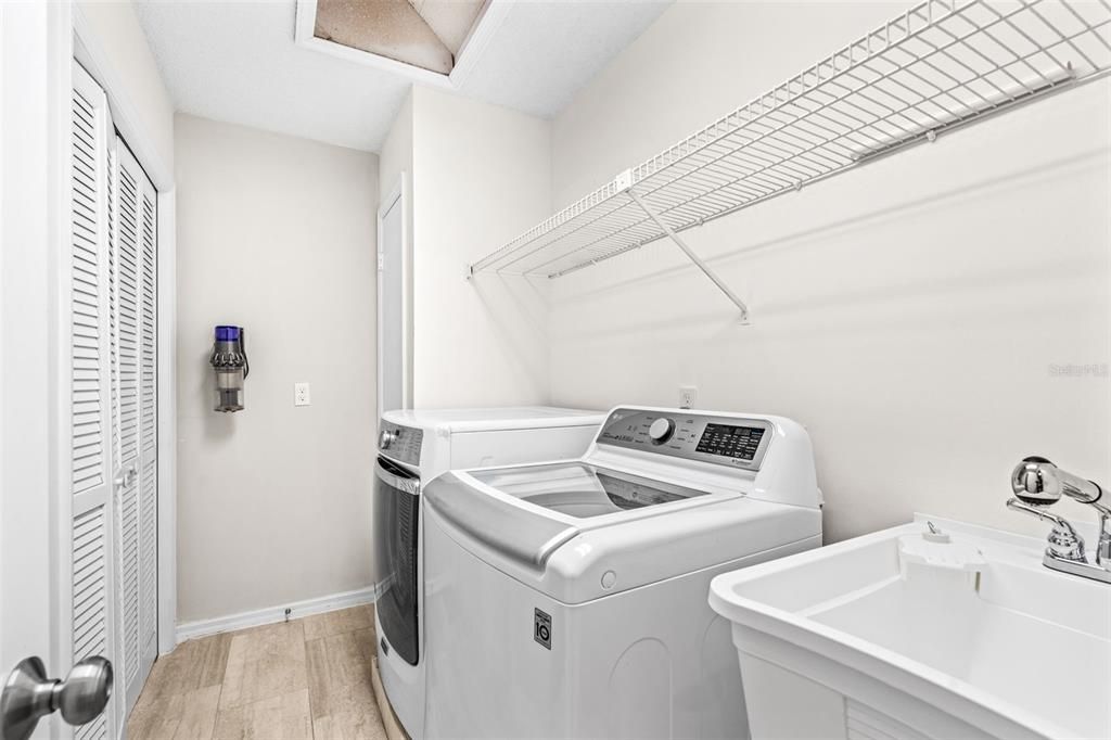 Interior laundry room with soaking sink and storage