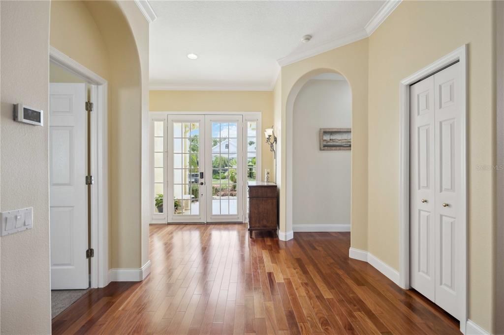 Step into the beautifully lit foyer through the large French doors that bring in incredible natural light and a view of the lush landscaping outside. Admire the high 10' ceilings with crown molding adding in that spacious and luxurious feeling as soon as you walk into this home.