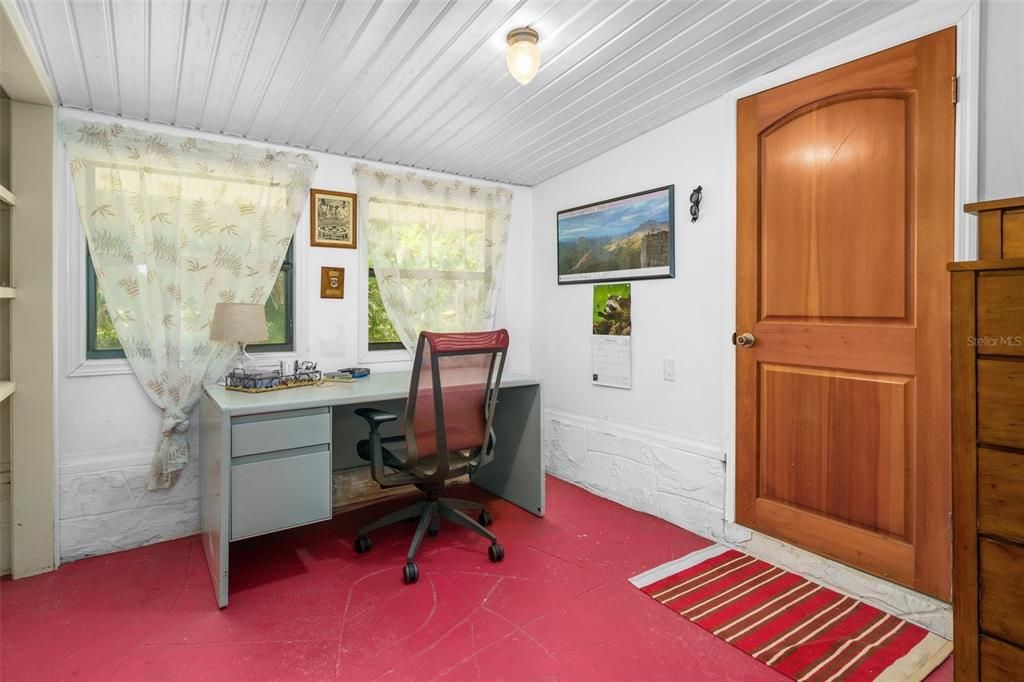 The Bonus room, currently used as an office is adjacent to the Family room. The wooden door leads to the attached Workshop/ Storage room.