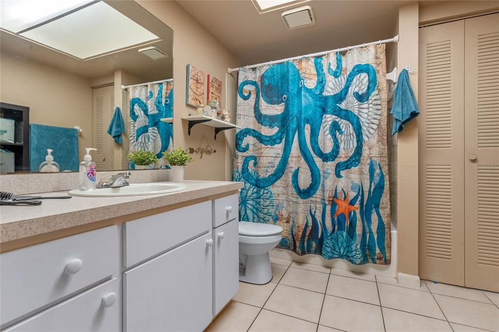 Bathroom features a linen closet and tub/shower unit