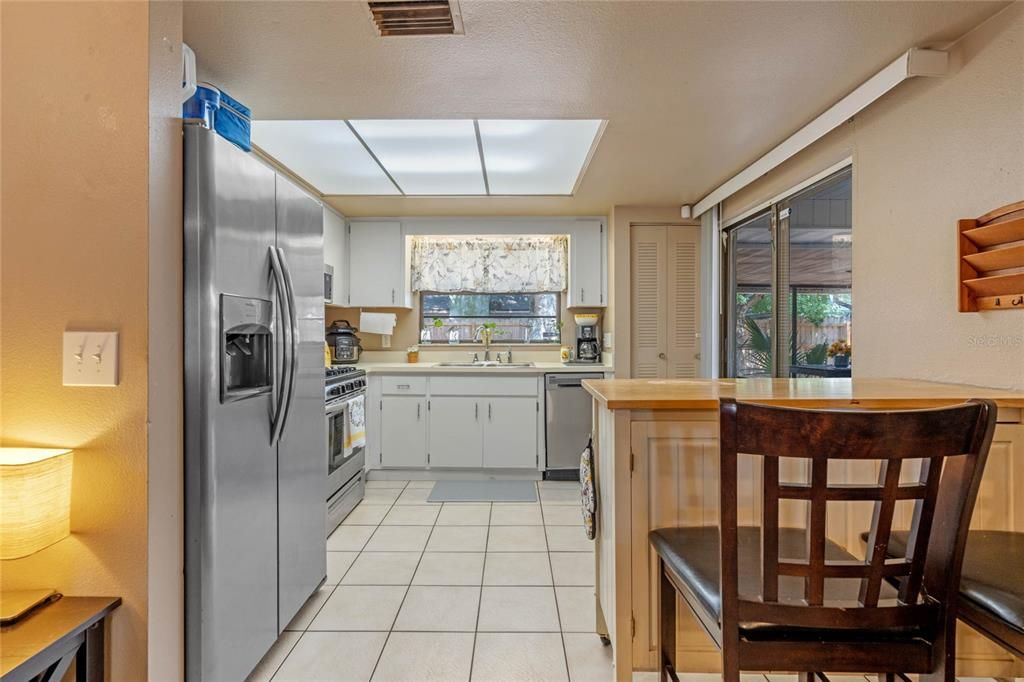 Kitchen features a portable island, closet pantry and glass sliding doors that lead on to the Screened in Porch