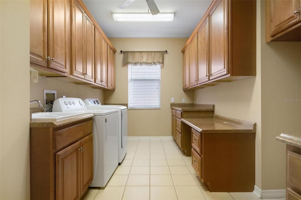 Huge laundry room including built-in desk and space for a standard size extra refrigerator