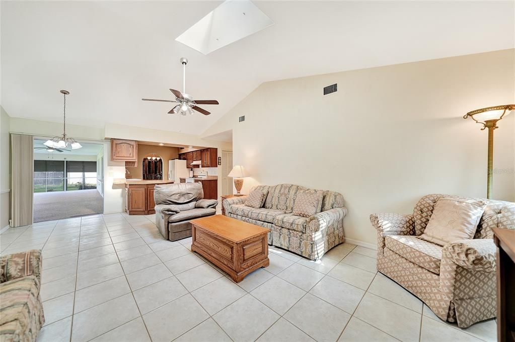 View from family room out to dinette area, pocket sliders to lanai- great fresh air with soaring ceilings and skylight.