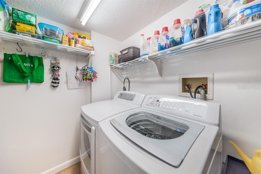 Utility room with LG Washer and Dryer including additional storage.