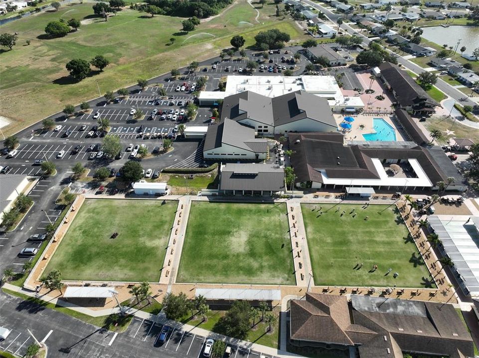 Aerial view of the central campus..lawn bowling, bocce ball, fitness center, multiple pools, shuffle ball, craft clubs, library, etc.