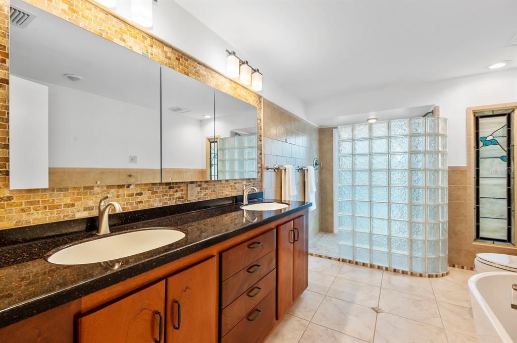 Owner's En-suite Bathroom with Custom cabinets, Stained Glass, features, Walk-in Shower, Separate Tub