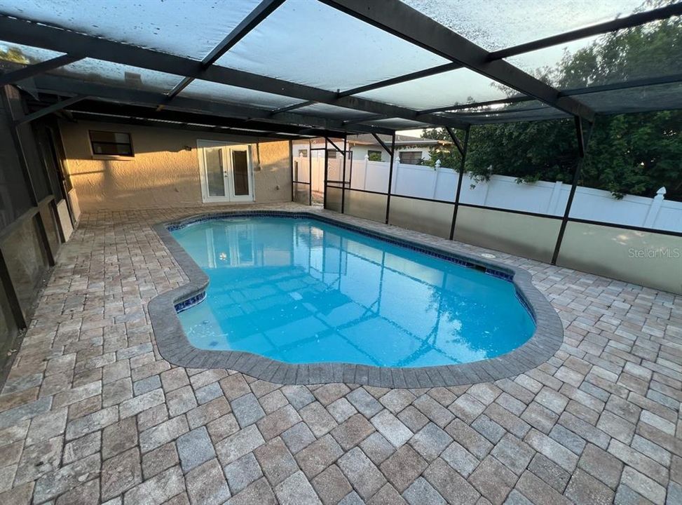 pool with pavered decking and lower privacy screening