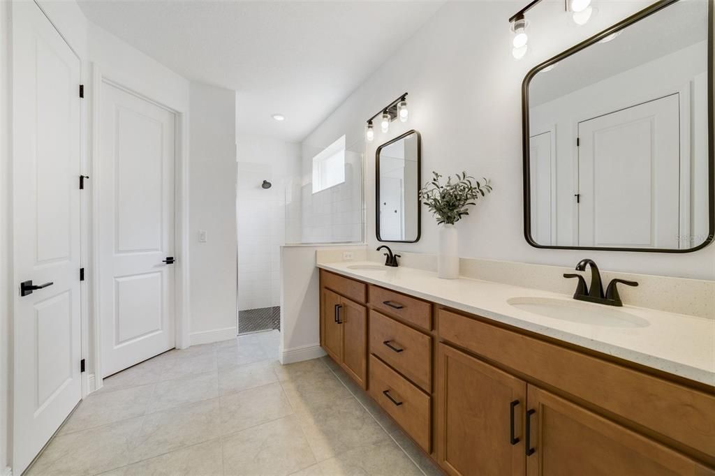 You will delight in the extended DUAL SINK VANITY with upgraded fixtures and decorative mirrors and large WALK-IN SHOWER.