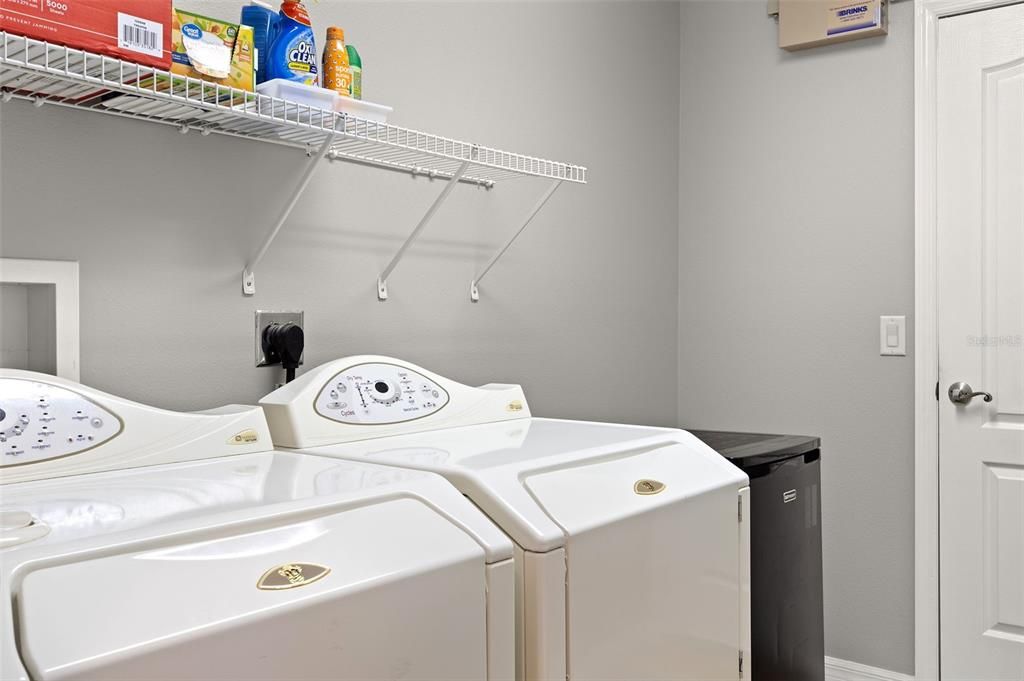 Laundry room with shelving for your convenience.