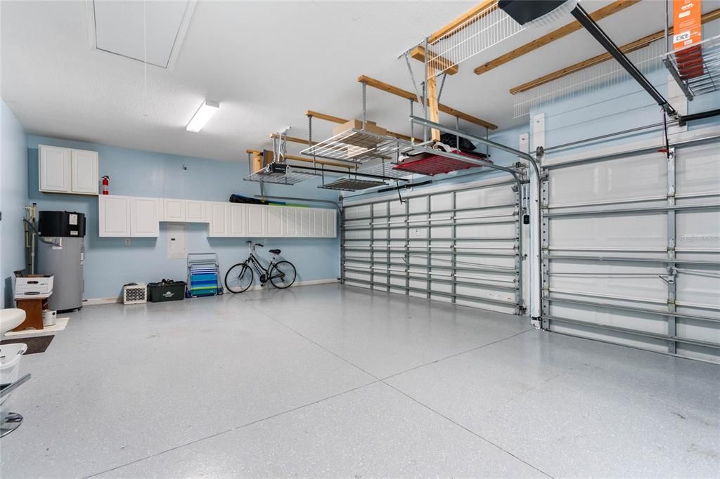 Epoxy finished garage floor with Multiple Overhead Storage Racks and Cabinetry