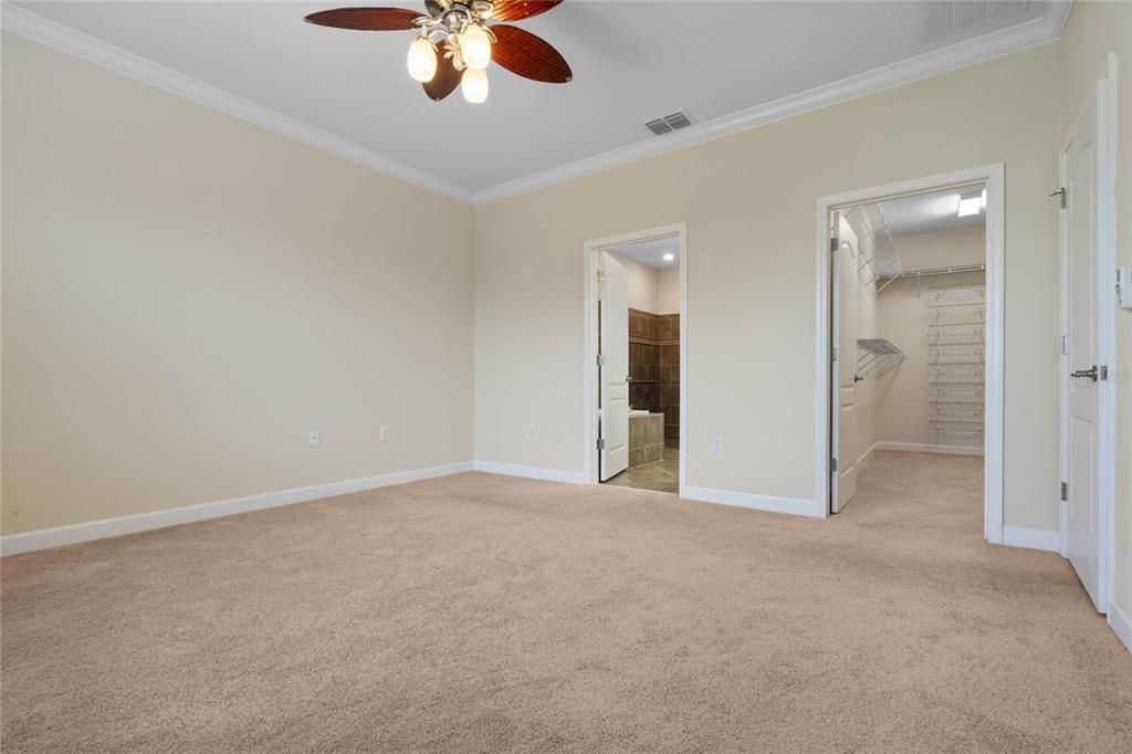 Wall to Wall Carpeting and Crown Molding enhance the Master Bedroom Suite