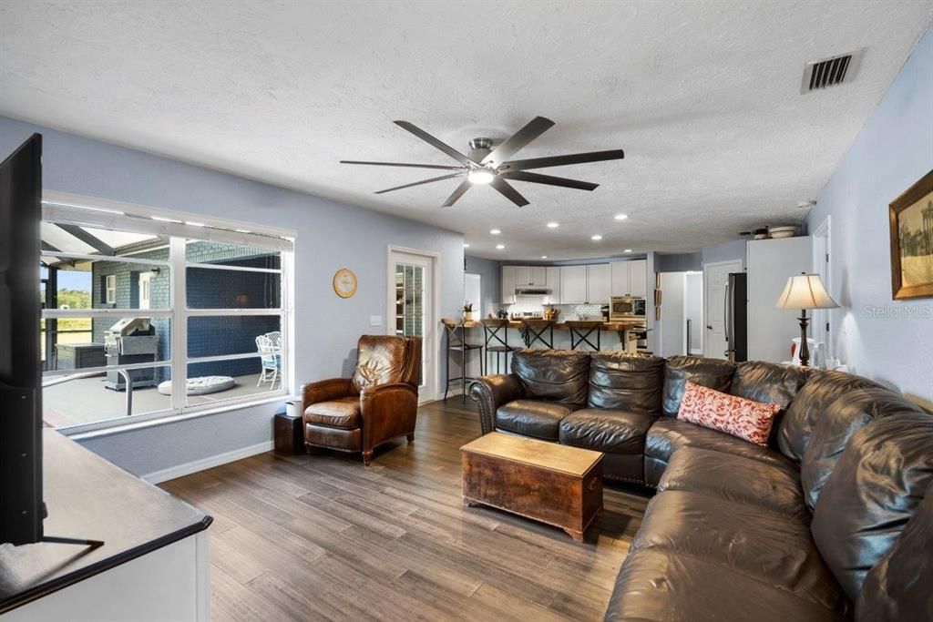 Family room featuring a large window and direct access to the screened-in lanai and heated pool.