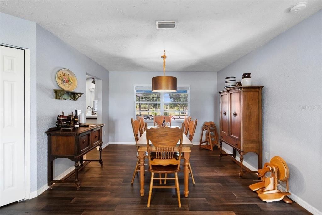 Dining Room featuring fossilized antique bamboo flooring, and a large window with views of the pool.