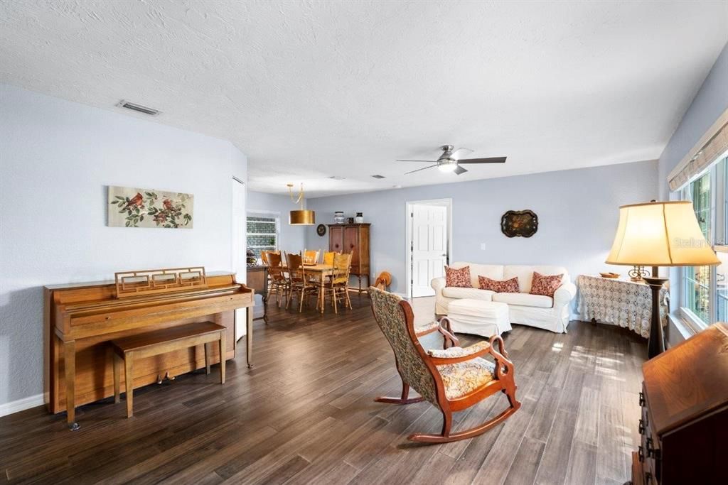 Living room/ Dining Room featuring fossilized antique bamboo flooring, large windows, and spacious layout.