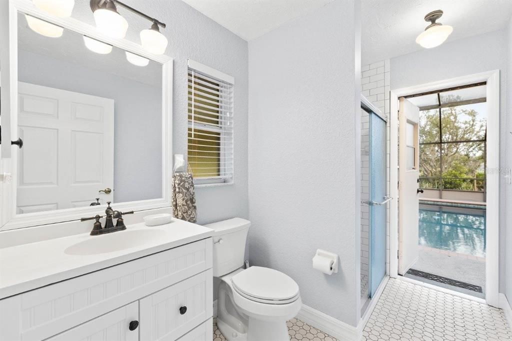 Guest bathroom #3 featuring a walk-in shower with direct access to the screened-in lanai and heated pool.