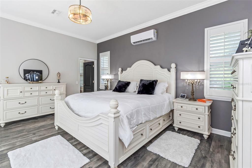 The primary bedroom offers the sleekness of luxury vinyl flooring, plantation shutters, beautiful ceiling fan and a ductless A/C for those times when you want to retreat in the coolness it brings without cooling the entire home.