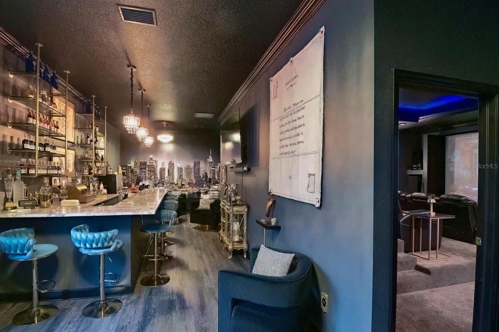 The flooring in the bar is luxury vinyl and waterproof. Notice the built-in refrigerator and whimsical antique cash register that conveys.