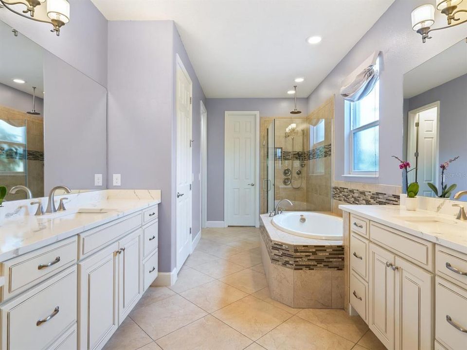 Primary ensuite bathroom offers two vanities, soaking tub, separate shower and private water closet.