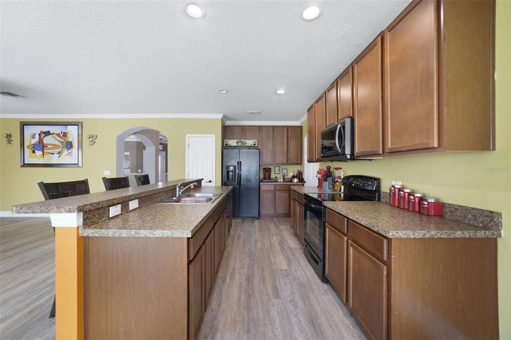 Prepare your favorite meal surrounded by rich 42” SOLID WOOD CABINETS, solid surface counters, quality appliances, a BREAKFAST BAR on the ISLAND and pantry for ample storage.