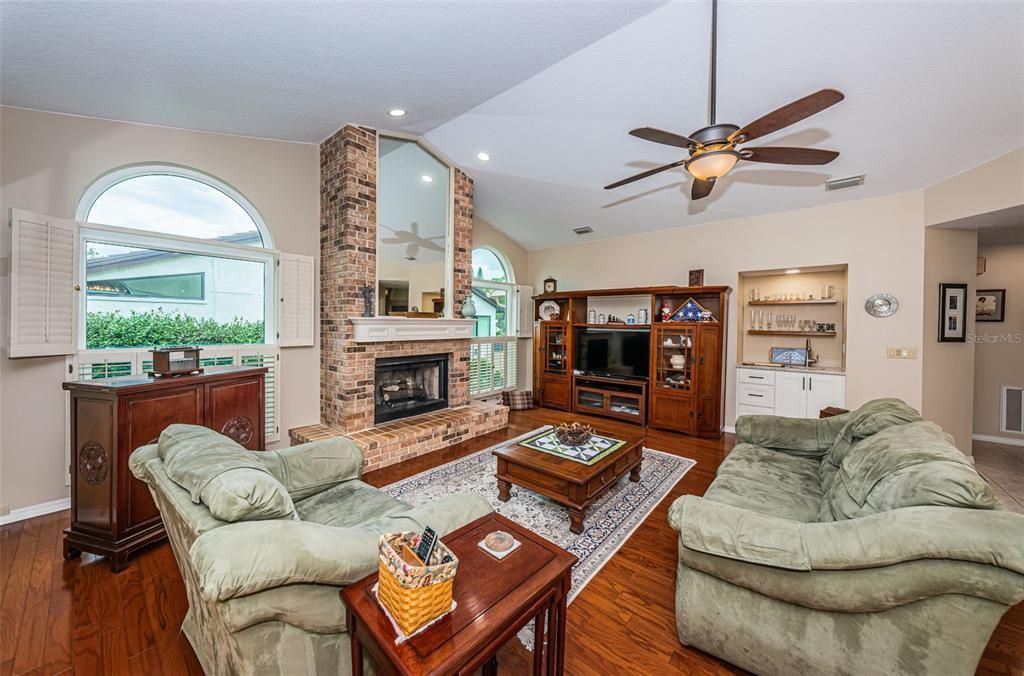 Spacious family room w/ gas fireplace, wood flooring, & wet-bar