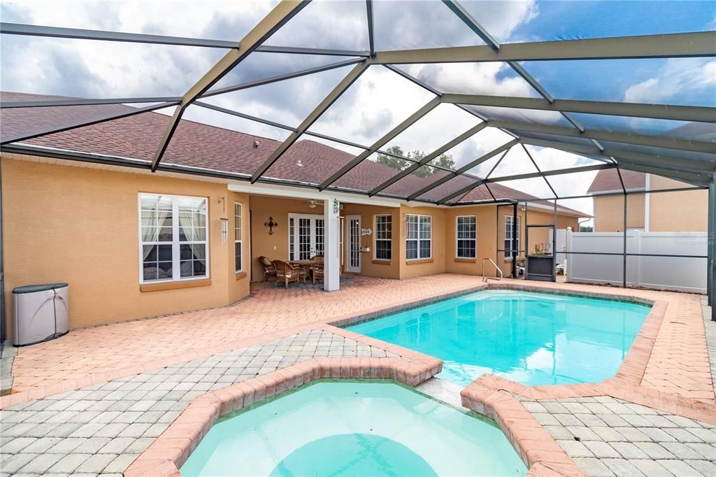 view of spa and pool looking towards Lanai of house (virtually staged)