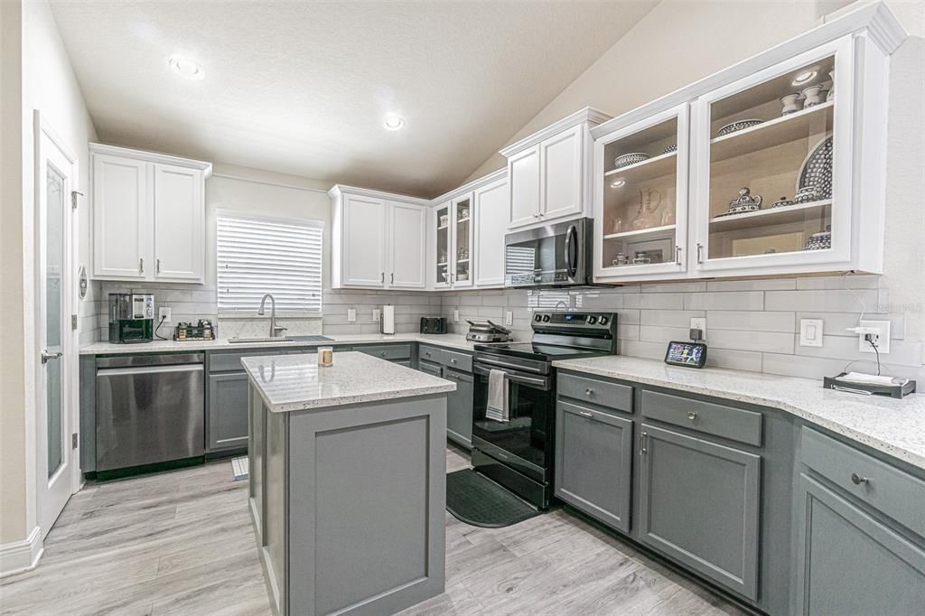 Beautiful kitchen with quartz, newer black stainless appliances and glass front cabinets!