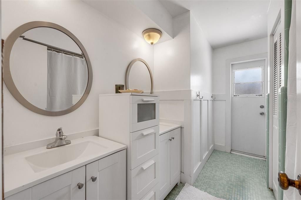 The guest bath includes dual sinks, a linen closet inside the bathroom, and a door to the pool area.