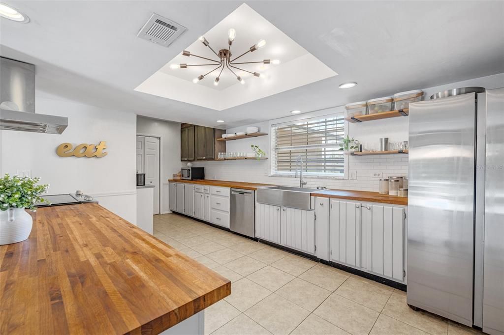 Kitchen updates include stainless steel appliances, a farmhouse sink, butcher block counters and floating shelves.