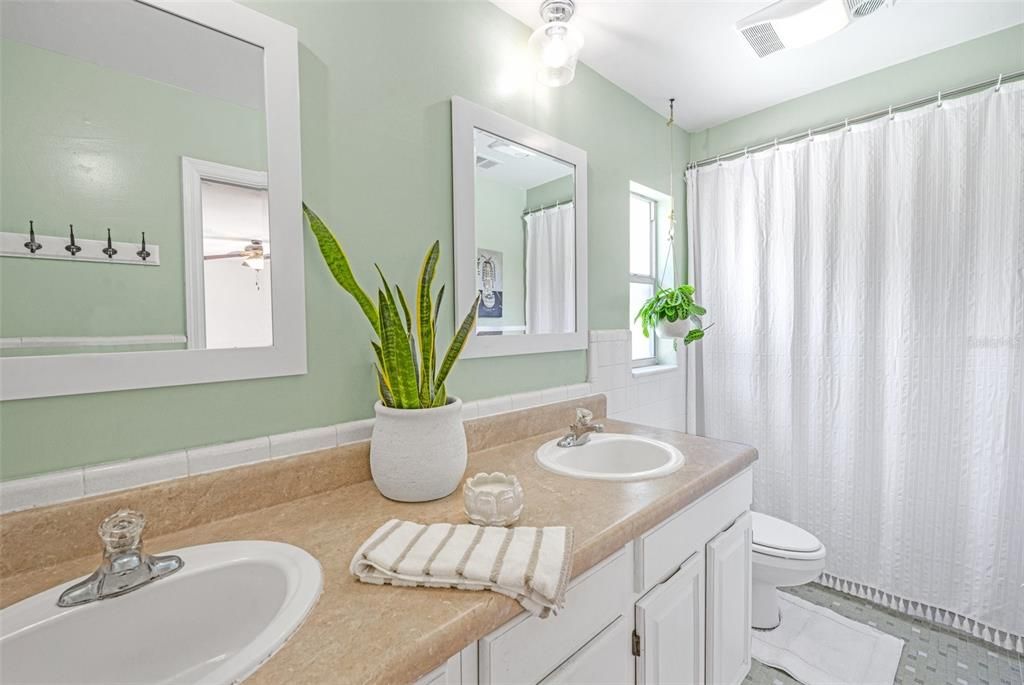 Updated mirrors, paint, and lighting fixtures make the primary bathroom feel even larger.