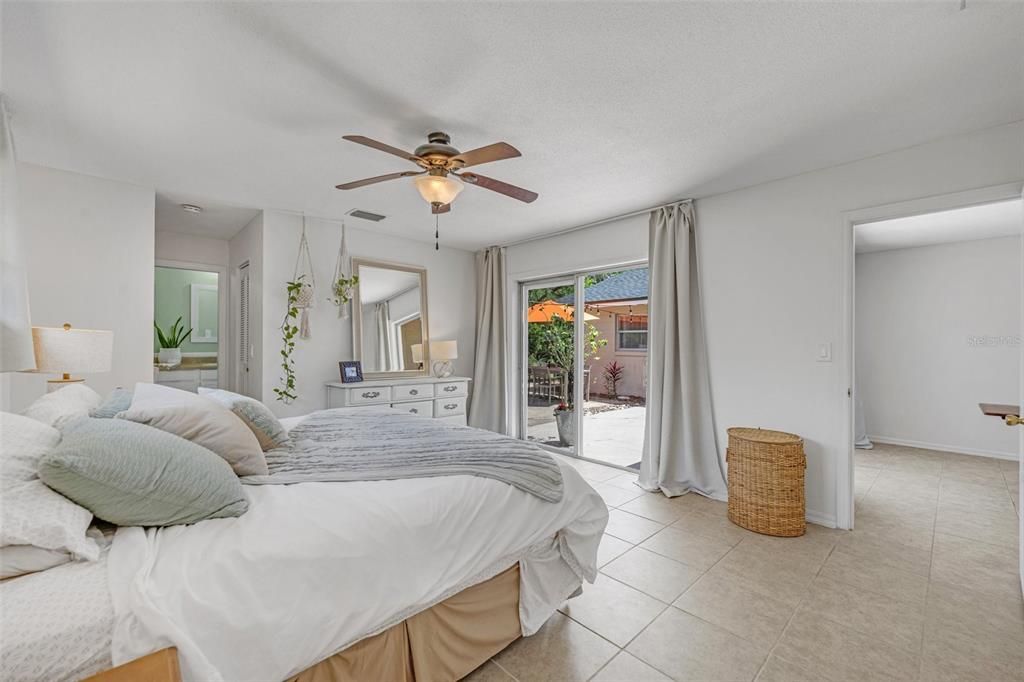 The primary bedroom offers pool views, a walk-in closet, a built in workspace, and a large bathroom.