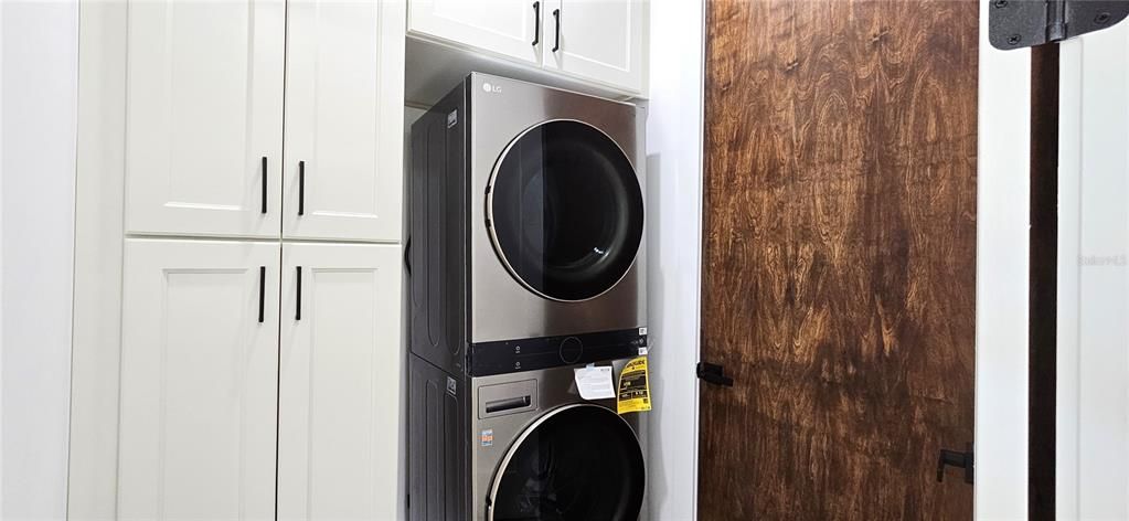 Interior laundry room is under AC, includes stackable washer & dryer, cabinets, storage