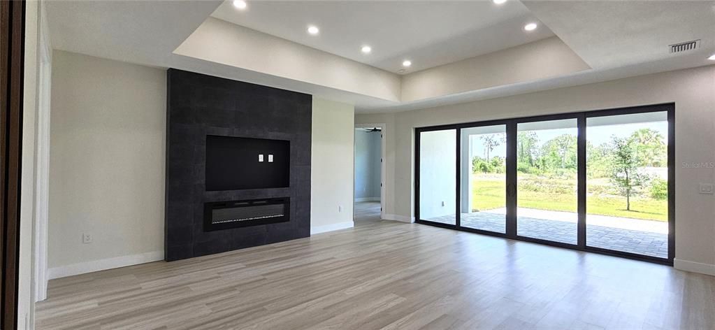 Family room includes Electric fireplace, trey ceiling with 8 can lighting fixtures, double pane glass sliders