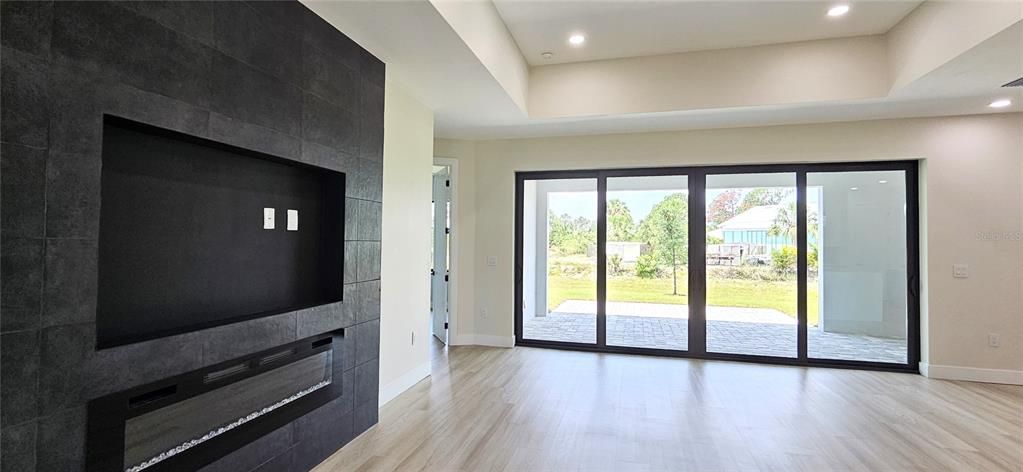 Family room includes Electric fireplace, trey ceiling with 8 can lighting fixtures, double pane glass sliders