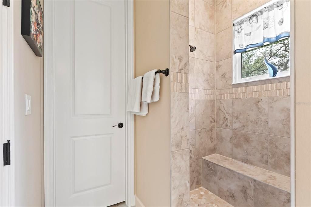 The shower has a sitting area.