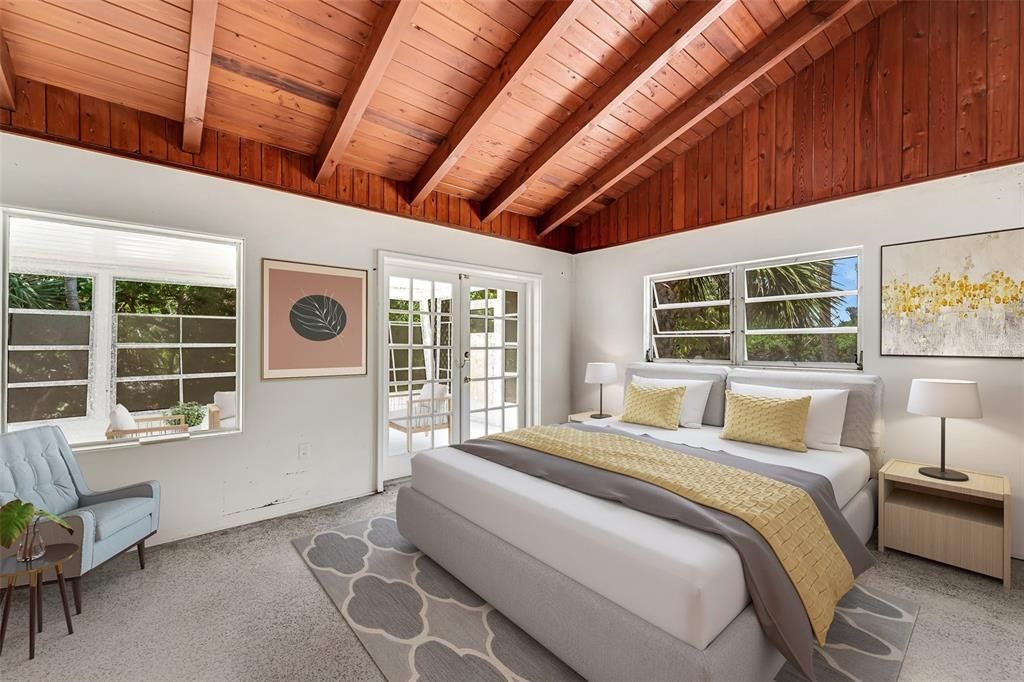 Back bedroom virtually staged. Wood cathedral ceilings and terrazzo floors. French doors lead to rear lanai.