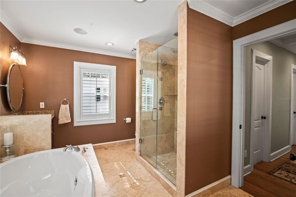 Primary bathroom with dual vanities, glass-enclosed shower and soak tub