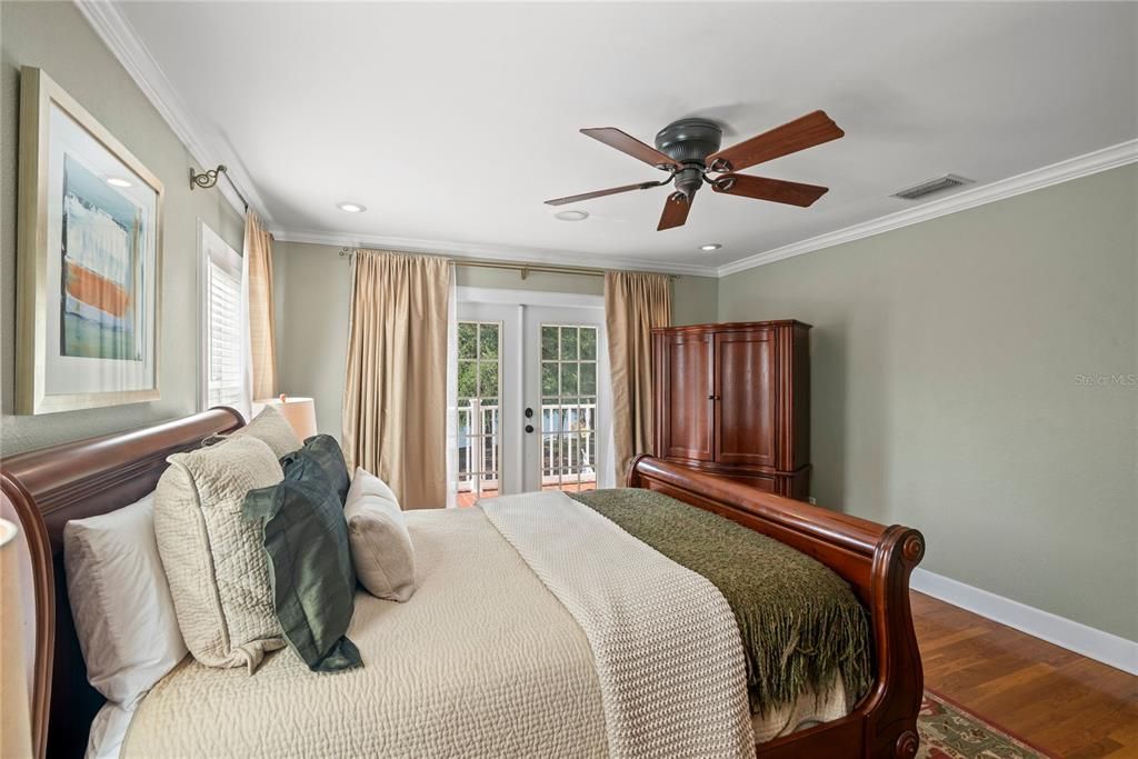 Primary bedroom with French doors leading to the private balcony