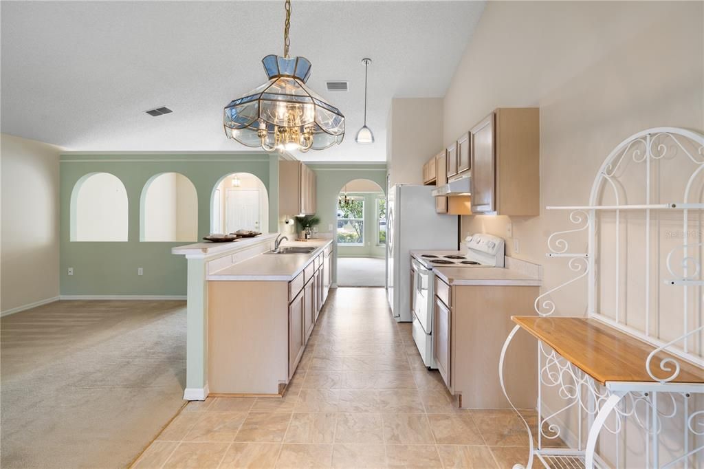 Open concept  living with kitchen and den together with vaulted ceiling