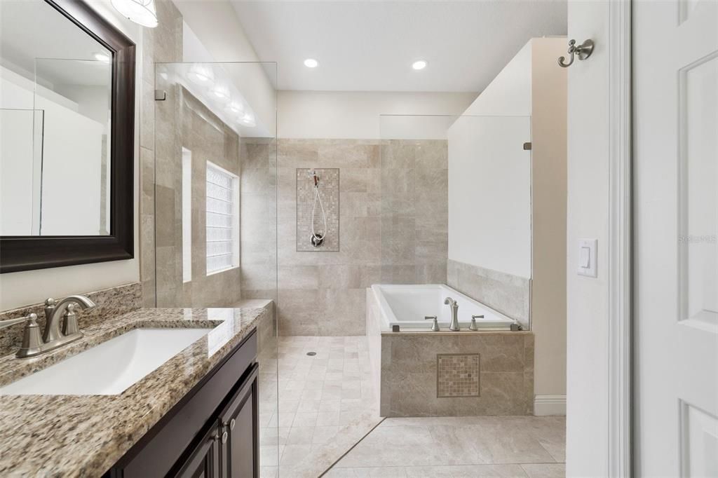 Private en-suite bath well appointed with an extended dual sink vanity and huge SHOWER and SOAKING TUB behind SEAMLESS GLASS.