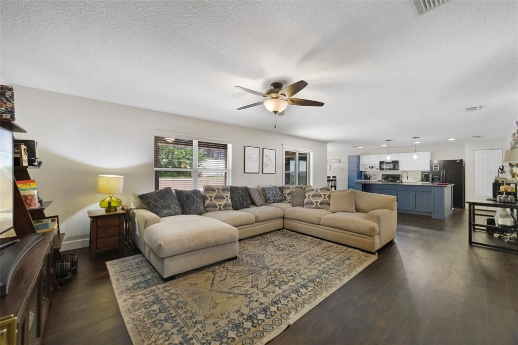 The spacious living area has sliding glass door access to the lanai and pool and is open to a chef’s dream kitchen.