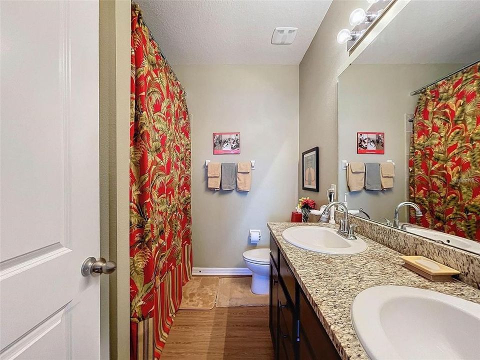 En suite with granite counters, shower and a linen closet