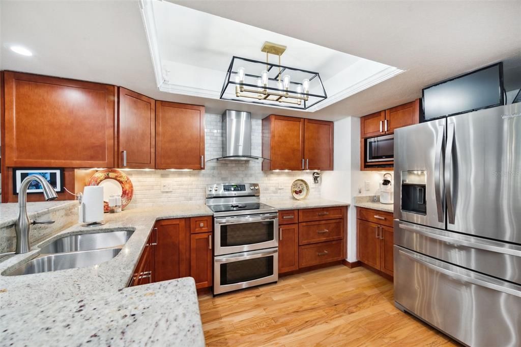 Enjoy granite countertops & Beverage Bar in your beautifully updated Kitchen with Stainless Appliances, Double Oven Range & Hood.