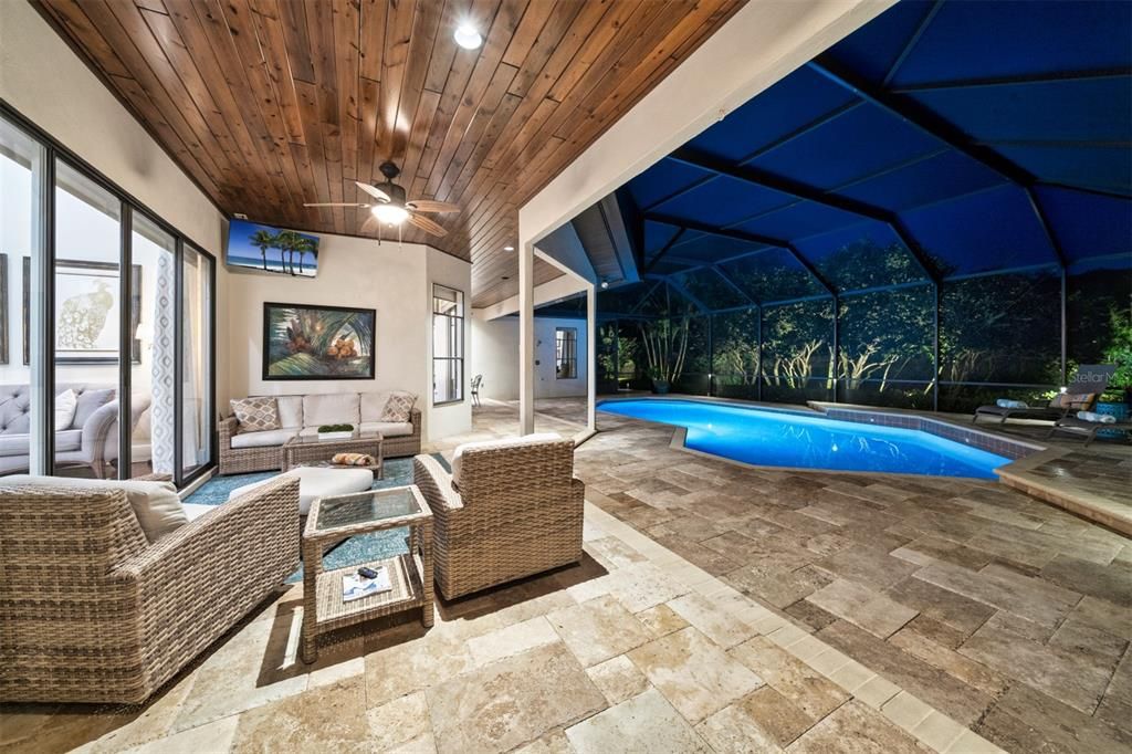 Travertine decking and tongue and groove ceiling overlooking the private backyard