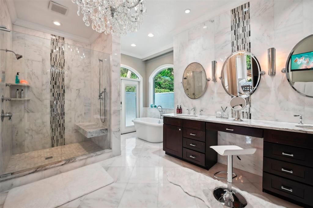 Luxurious master bathroom with  Carrera  Marble, shower with multiple shower heads, separate bath and walk out to private courtyard
