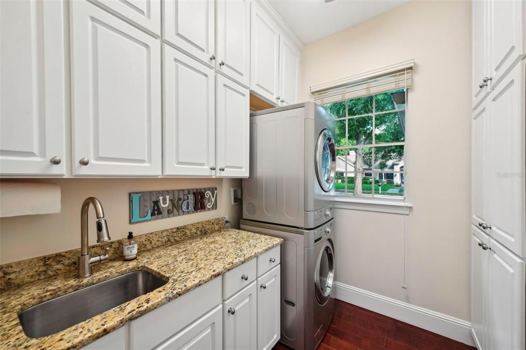 Spacious laundry room with loads  of cabinets, utility sink and washer and dryer included
