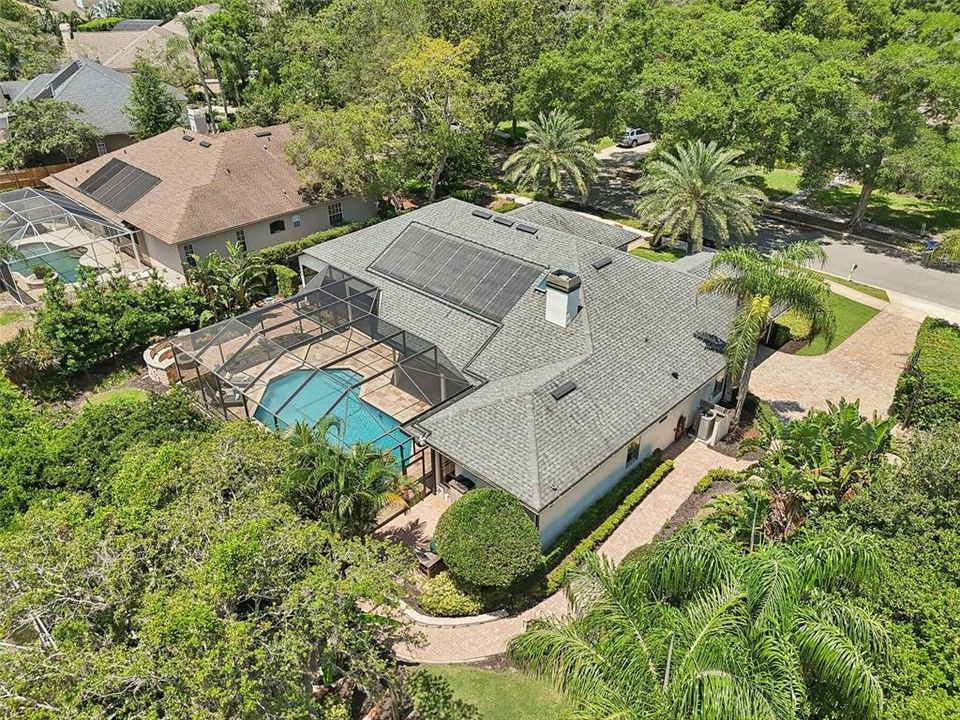 Aerial view showing paver walkway from driveway and luscious landscape