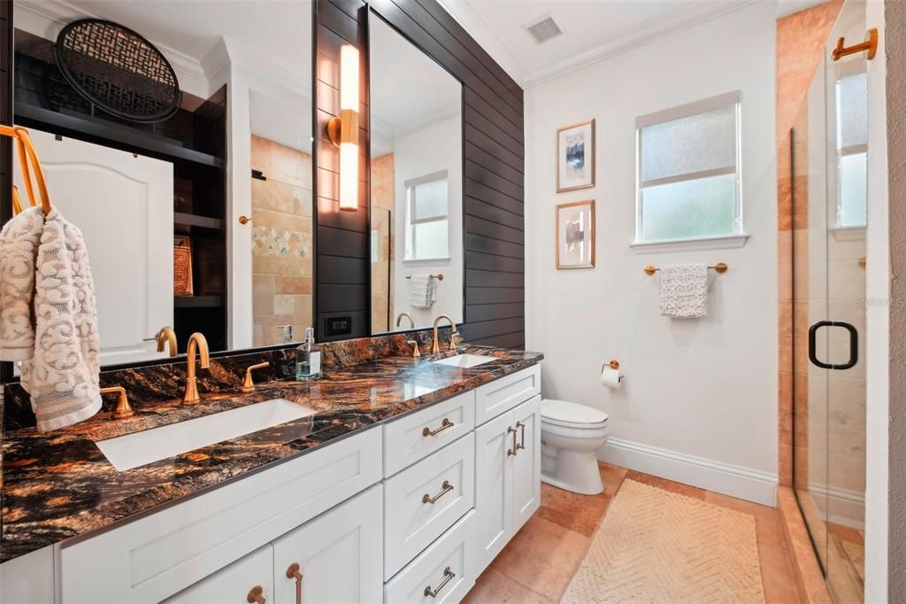 Remodeled in 2022 the secondary bathroom includes new cabinets, granite counter tops, wood wall and fixures