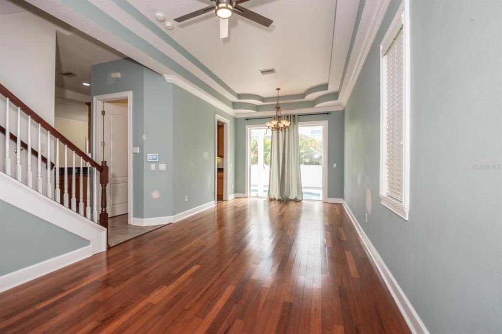 Formal Living Room & Dining Room Combination Space, With Gleaming Hardwood Flooring & Tray Ceiling, and Slider Door Exit To Lanai, Pool & Backyard!