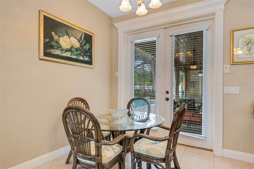 The adjacent casual dining area also boasts glass french doors leading to the pool and lanai area.