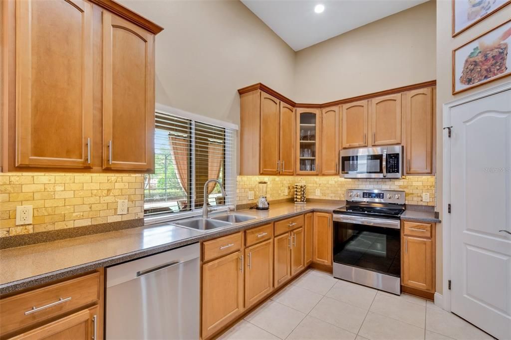 Easy care solid countertops and a full tile backsplash all around.